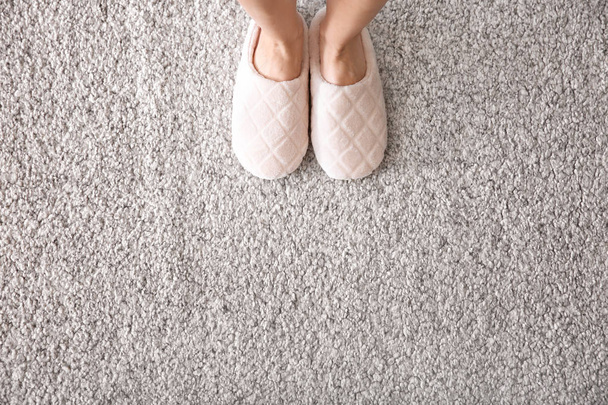 Femme en pantoufles debout sur le tapis
 - Photo, image