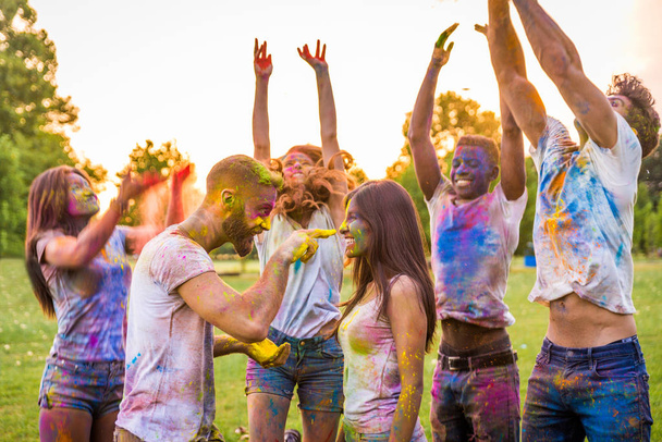 Group of happy friends playing with holi colors in a park - Young adults having fun at a holi festival, concepts about fun, fun and young generation - Valokuva, kuva