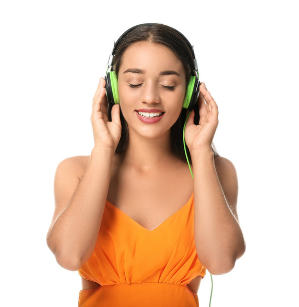 Красивая молодая женщина слушает музыку на белом фоне - Фото, изображение