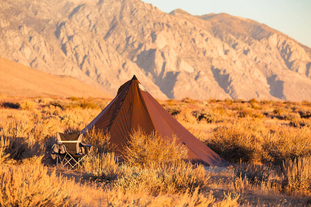 Tente tipi style indien avec chaise de camp pliante à proximité, dressée dans le désert sous les montagnes de la Sierra Nevada
 - Photo, image