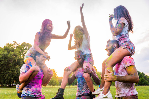 Group of happy friends playing with holi colors in a park - Young adults having fun at a holi festival, concepts about fun, fun and young generation - Foto, immagini
