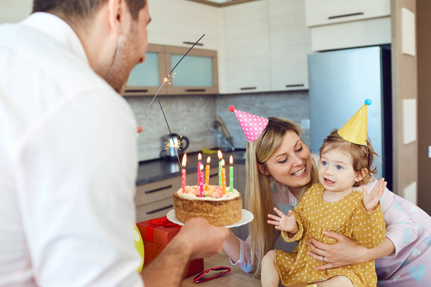 A family with a cake congratulates a happy child on his birthday - Foto, immagini