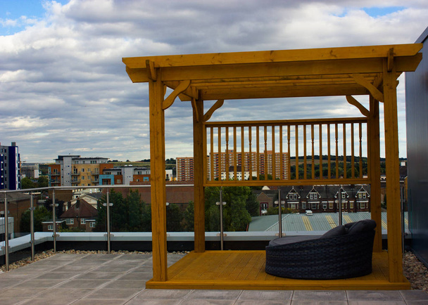 gazebo en bois sur le toit avec un fauteuil
 - Photo, image