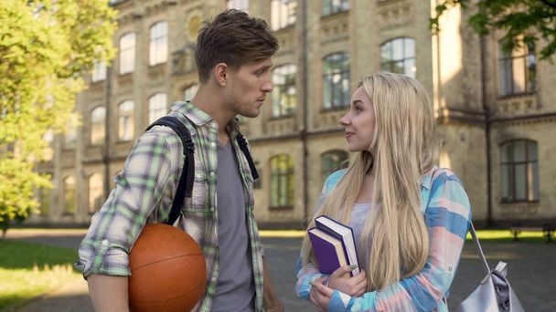 Young sportsman talking with beautiful blonde near college, asking for date - Zdjęcie, obraz