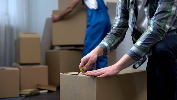 Man unpacking things in new apartment, moving company worker bringing boxes - Photo, image