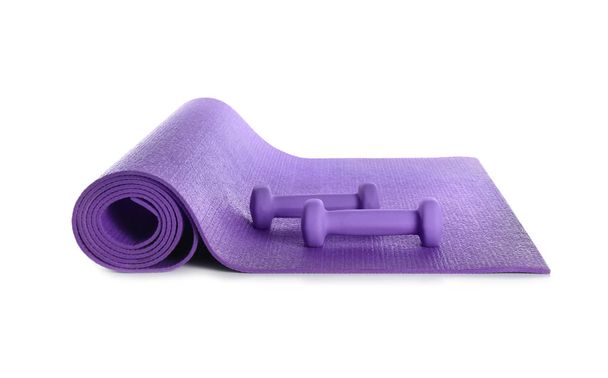 Farbe Yogamatte mit Kurzhanteln auf weißem Hintergrund - Foto, Bild