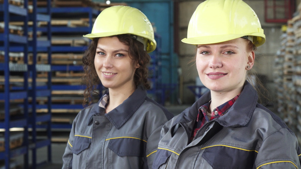 Female engineers wearing protective hardhats smiling to the camera  - Photo, Image