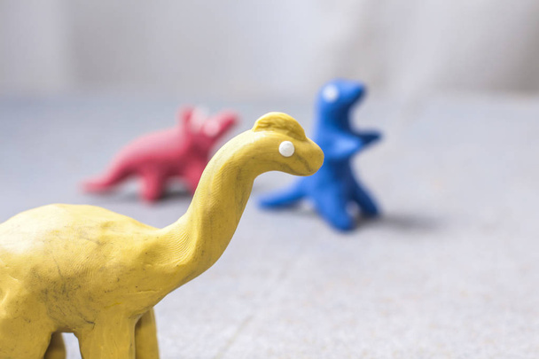 dinosaures en plasticine aux couleurs vives, moulés à la main pour jouer
 - Photo, image