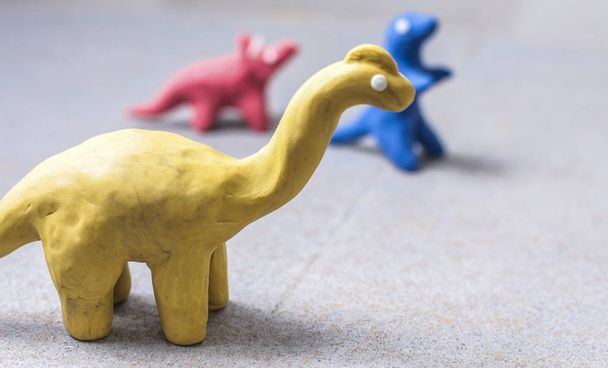 dinosaures en plasticine aux couleurs vives, moulés à la main pour jouer
 - Photo, image