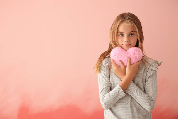 Мила дівчинка з плюшевим серцем на кольоровому фоні
 - Фото, зображення