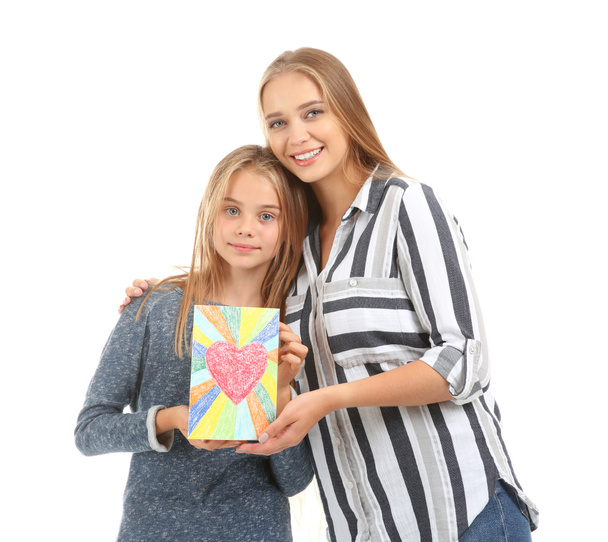 Cute little girl and her mother with greeting card on white background - Valokuva, kuva