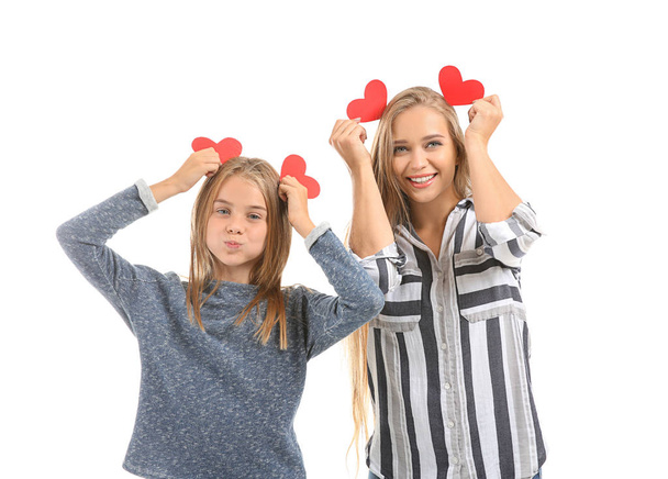 Cute little girl and her mother with red hearts on white background - Fotoğraf, Görsel