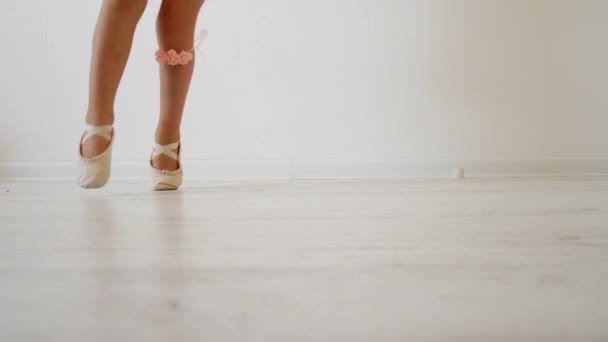 Little ballerina dancing on a white background. Attempt to dance on fingers - Felvétel, videó