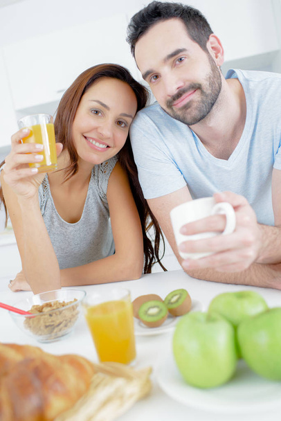 a happy couple eats breakfast together - Foto, Imagem