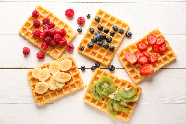 Delicious waffles with fruits and berries on white wooden background - Φωτογραφία, εικόνα