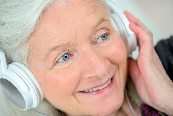 senior woman listening music with headphones - Фото, изображение