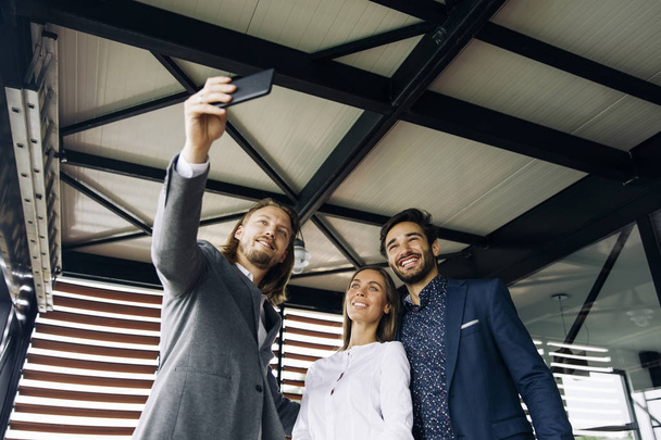 Retrato de gente sonriente de negocios posando para selfie
 - Foto, Imagen