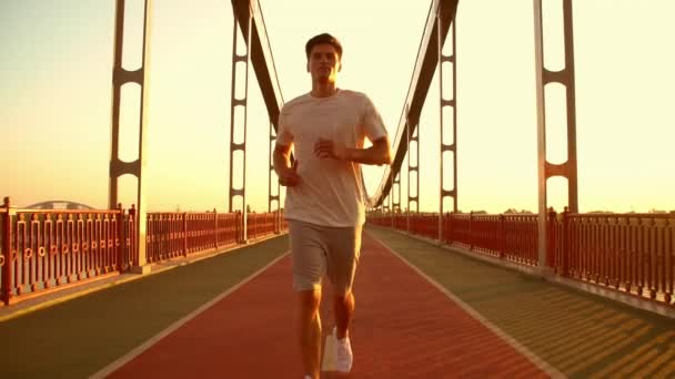 człowiek biegnie wzdłuż mostu - Materiał filmowy, wideo