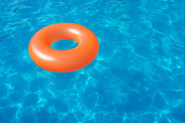 Puhallettava rengas kelluu uima-altaassa aurinkoisena päivänä. Tekstitila
 - Valokuva, kuva