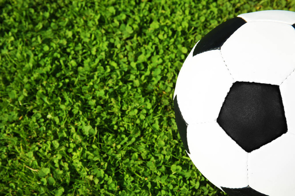 Soccer ball on fresh green football field grass, top view. Space for text - Photo, Image