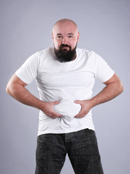 Fat man on grey background. Weight loss - Photo, Image