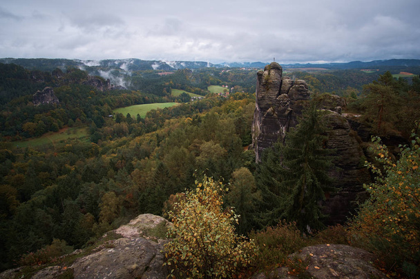 Misty fog mountains from viewpoint of Bastei in Saxon Switzerland, Germany to the mountains at sunrise in the morning fog, National park Saxon Switzerland - Fotoğraf, Görsel