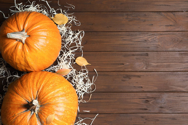 Flat lay composition with pumpkins and space for text on wooden background. Autumn holidays - Fotoğraf, Görsel