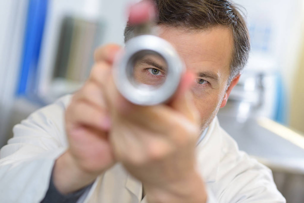 View of male scientist through metal tube - Photo, Image