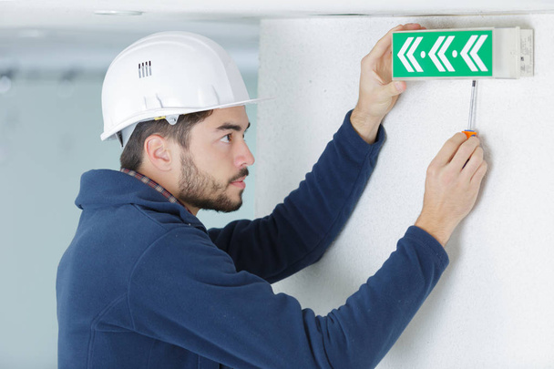 young male electrician testing lighting sign - Photo, image
