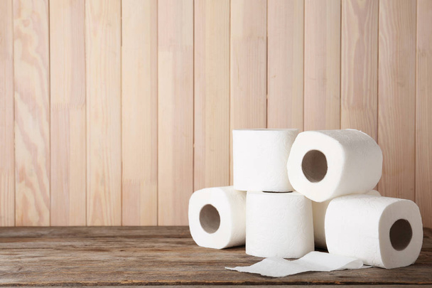 Rolls of toilet paper on wooden table. Space for text - Φωτογραφία, εικόνα