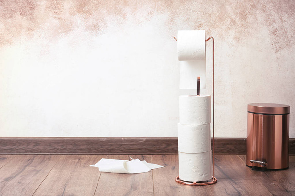 Toilet paper holder with rolls on floor indoors. Space for text - Fotoğraf, Görsel