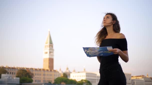 Приваблива молода жінка подорожує Європою і вивчає прекрасні краєвиди в Барселоні, сонячні лінзи спалахують, повільний рух, хіпстерська дівчинка носить окуляри і тримає карту туризму, насолоджуючись святом. - Кадри, відео