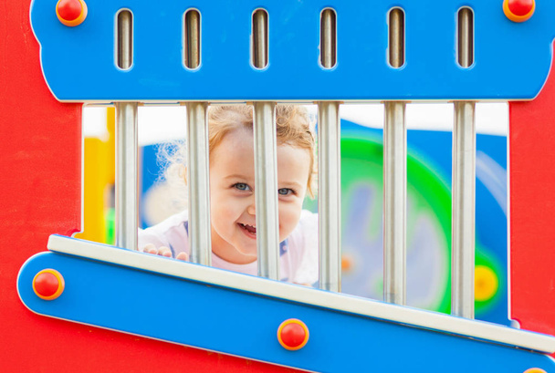 Bella bambina con i capelli biondi e gli occhi azzurri gioca all'aperto in una giornata estiva
. - Foto, immagini