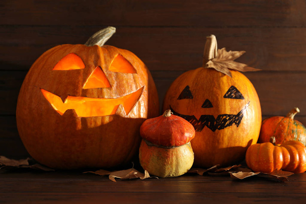 Halloween pumpkin head jack lanterns on table against wooden background - Fotografie, Obrázek