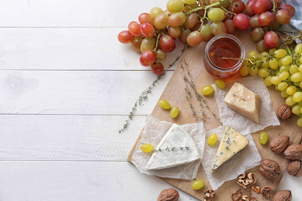 Raisins juteux mûrs au fromage et noix sur table en bois clair
 - Photo, image