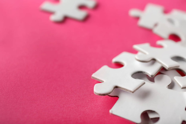 Pieces of jigsaw puzzle on color background, closeup - Foto, afbeelding
