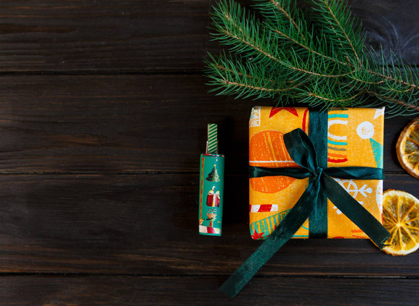 present in orange and green paper on the wooden background  for friends and family. shopping,  New year and Christmas concept. close up, copy space - Fotó, kép