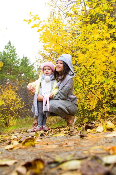 Mom and little daughter are walking in the autumn park - Foto, Bild