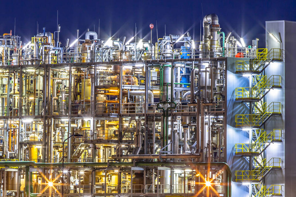 Nachtszene einer schweren chemischen Industrieanlage mit Details des Rohrlabyrinths in der Dämmerung - Foto, Bild