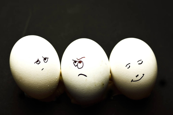 Egg represents human face isolated against black background - Photo, Image