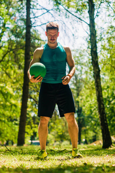 Zdravý mladý muž cvičení s míčem lékařství v přírodě - Fotografie, Obrázek
