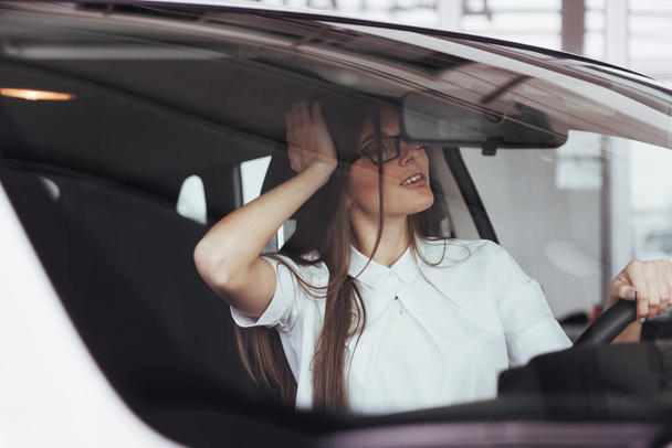attractive young Caucasian woman looking at the camera from the front seat of the car - Fotografie, Obrázek