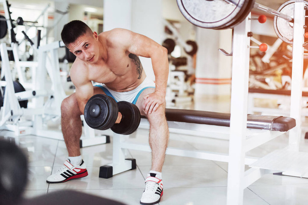 Portrait of a beautiful athletic guy muscles with weights in the gym. Sport. Fitness - Fotoğraf, Görsel