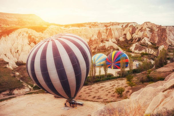 Colorful hot air balloons flying over Red valley at Cappadocia, Anatolia, Turkey. Volcanic mountains in Goreme national park. - Фото, зображення
