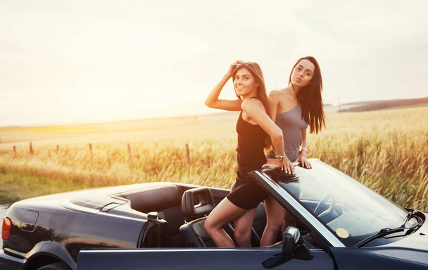 Two women in a black car on the roadside roads. - Fotografie, Obrázek