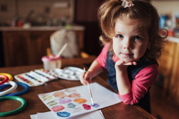 Cute happy little girl, adorable preschooler, painting with water color on canvas. Baby close up. - 写真・画像