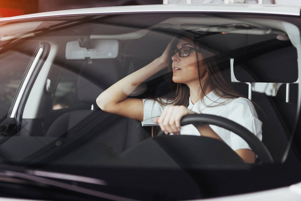 attractive young Caucasian woman looking at the camera from the front seat of the car - Foto, Imagen