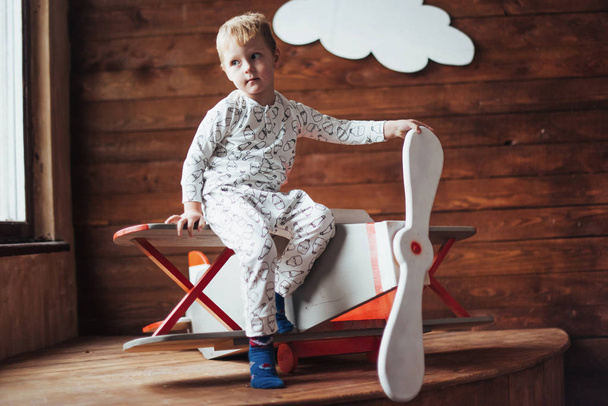 Niño feliz jugando con aviones de madera en contra. Infancia. Fantasía, imaginación. Vacaciones
 - Foto, Imagen