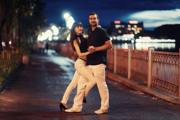 jovem casal dançando tango no dique do rio à noite
 - Foto, Imagem