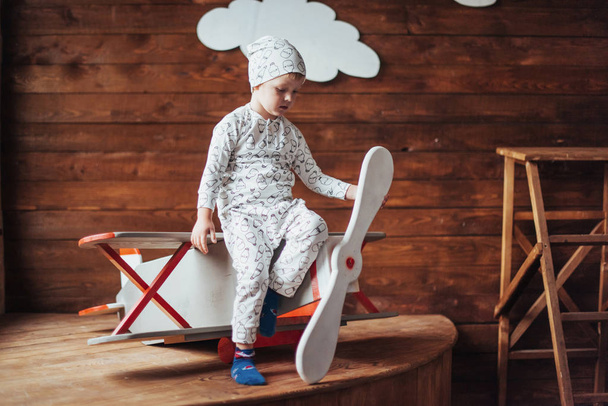 Happy kid playing with wooden airplane against. Childhood. Fantasy, imagination. Holiday - Φωτογραφία, εικόνα